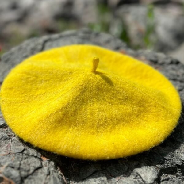 yellow beret lying on the grey stones