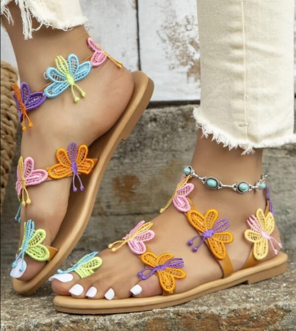 woman wearing butterfly sandals, ankle bracelet and white jeans