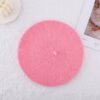 candy pink beret on the white background, a white candle next to it