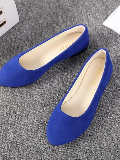 dark blue flats front view, standing on a grey carpet