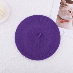 dark purple beret lying on the white table, an image of the cat next to it