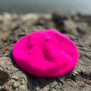 fuchsia beret lying on the grey stones