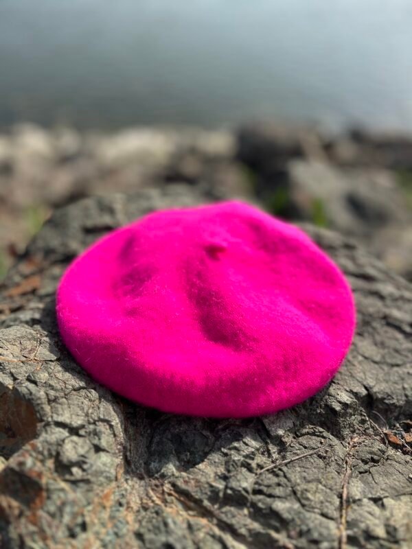 fuchsia beret lying on the grey stones