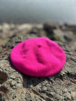 fuchsia beret lying on the grey stones