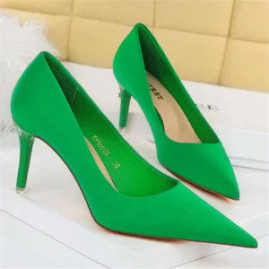 green pointed toe heels front and side view standing on a white carpet