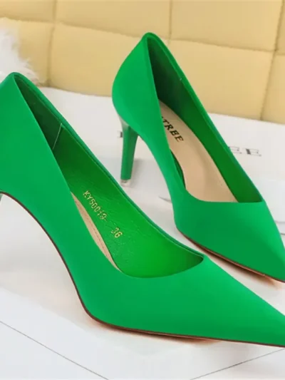 green pointed toe heels standing on a white carpet