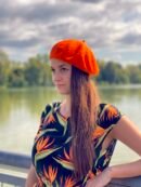 woman wearing orange beret and black dress with orange flowers