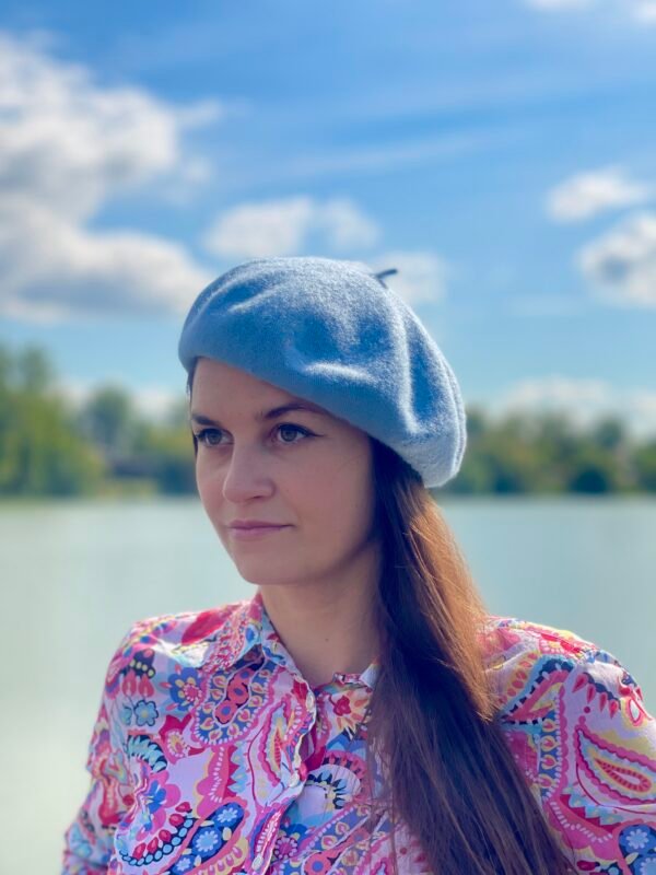 woman wearing pale blue beret, the sky in the background