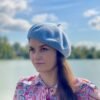 woman wearing pale blue beret, the sky in the background