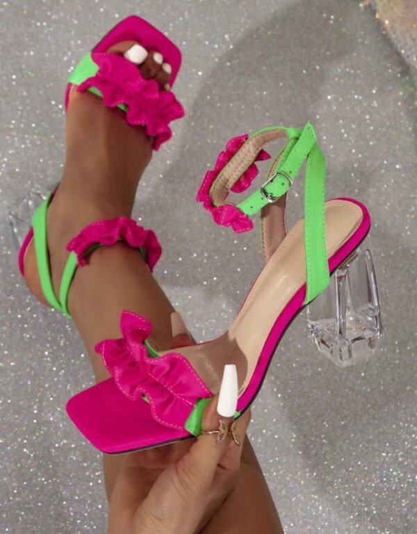 woman wearing one pink and green sandal and holding the other one exposing its side part