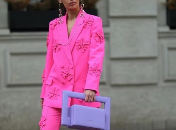 woman wearing pink blazer with appliques and a lilac bag