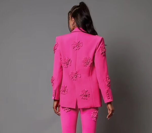 woman turned to her back wearing pink blazer with appliques