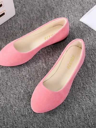 pink flats front view standing on a grey carpet