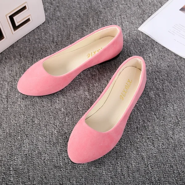 pink flats front view standing on a grey carpet