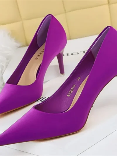 purple heels front standing on a white carpet