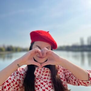 red beret on a model, lake and blue sky in the background