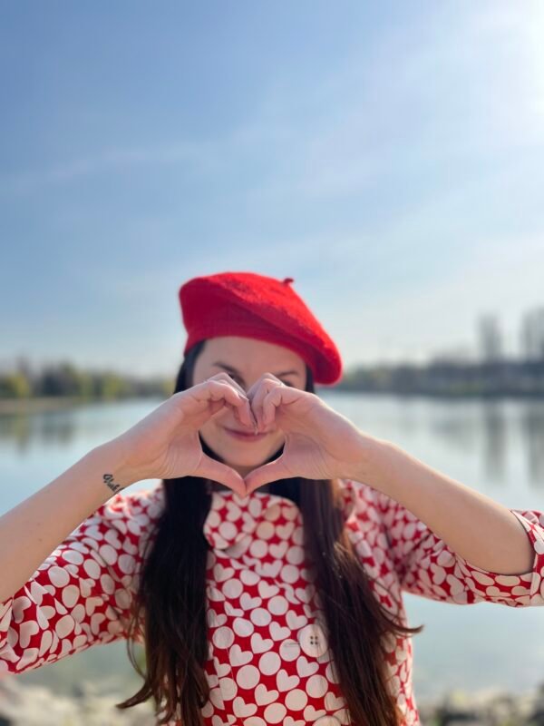 red beret on a model, lake and blue sky in the background