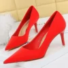 red pointed toe heels standing on a white carpet