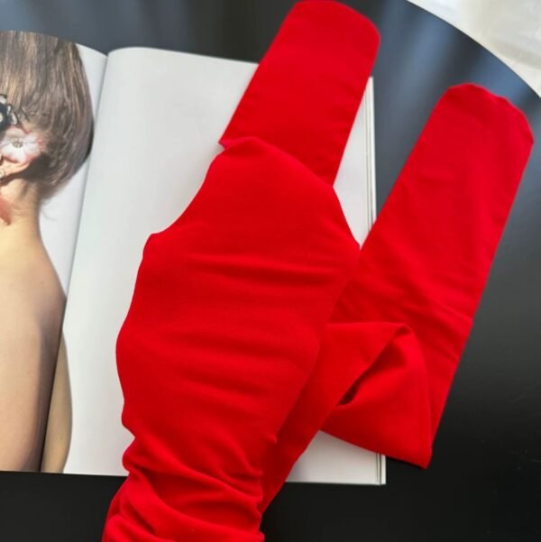 the material of red tights on the black table, an open magazine next to it