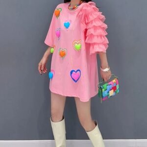 pink dress with hearts front view on a model, grey wall in the background