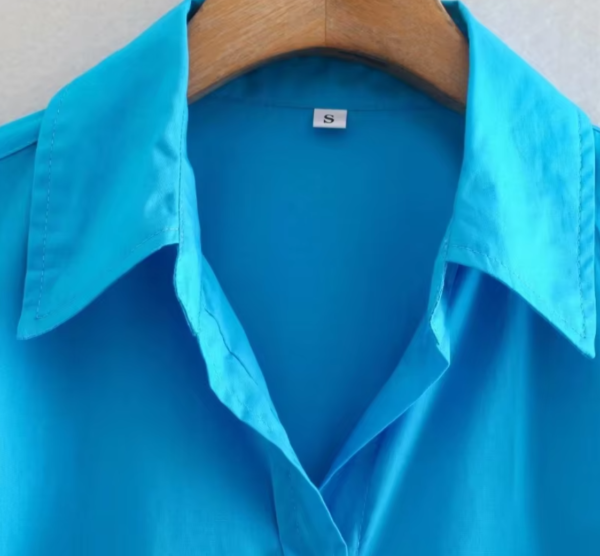 turquoise blouse front view on a hanger, the collar is shown