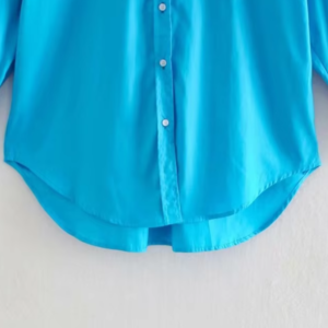 turquoise blouse front view on a hanger, bottom part visible