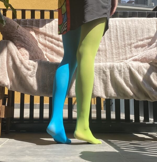 woman turned to her back wearing two color colorful tights, green and blue variation