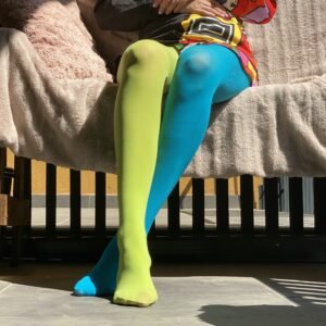 woman sitting in two colors colorful tights, they are green and blue