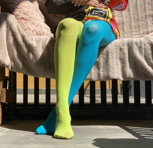 woman sitting in two colors colorful tights, they are green and blue