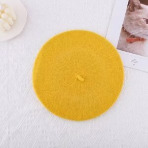 yellow beret on the white background, a white candle next to it