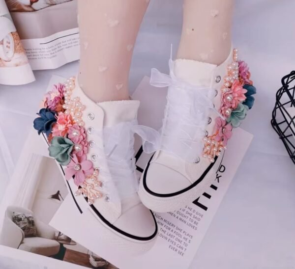 woman wearing floral sneakers, white magazine under her