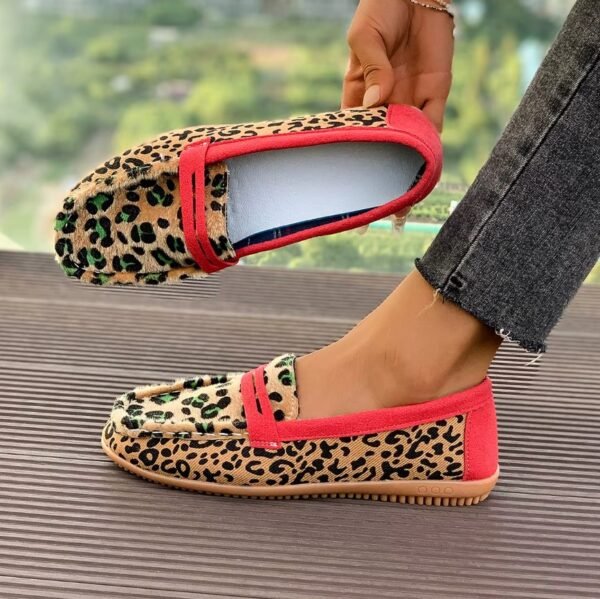 woman wearing one leopard print loafer and holding the other one exposing its inside design