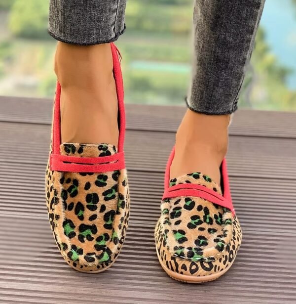 woman wearing leopard print loafers on the brown floor