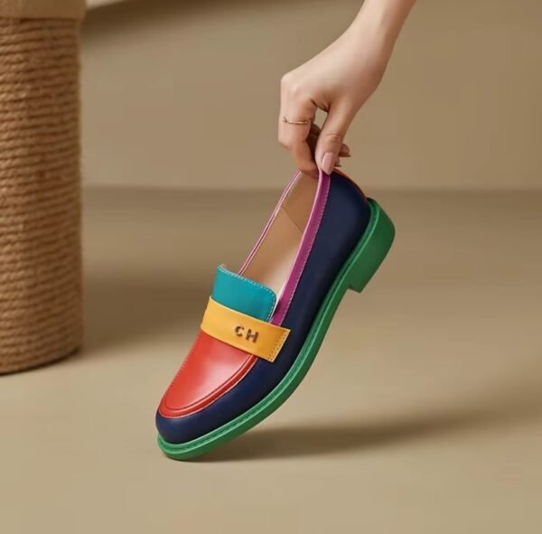 woman is holding a multicolor loafer on the beige background