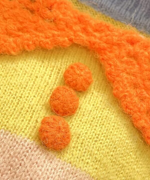 the orange buttons of the cute orange sweater