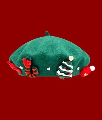Christmas beret in a green color on the red background