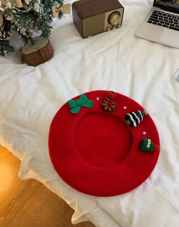 Christmas beret, red variation, lying on the white bed, a Christmas tree and a retro radio next to it