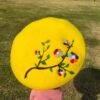 colorful embroidered beret, grass in the background