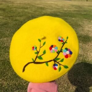 colorful embroidered beret, grass in the background