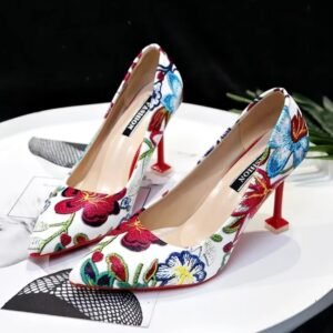 colorful floral heels standing on the white table, black wall in the background