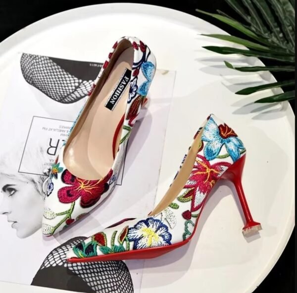 colorful floral heels, their front and side visible, standing on the white table