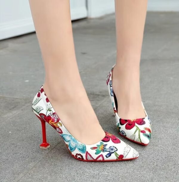 woman standing on the grey ground in colorful floral heels