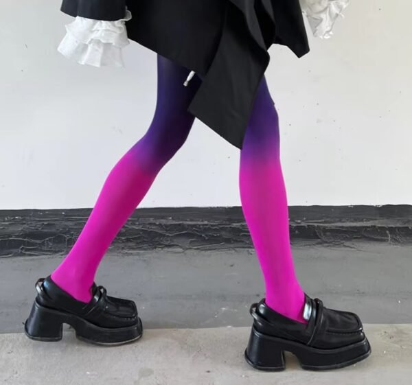 woman walking on a grey floor in purple colorful gradient tights and black shoes