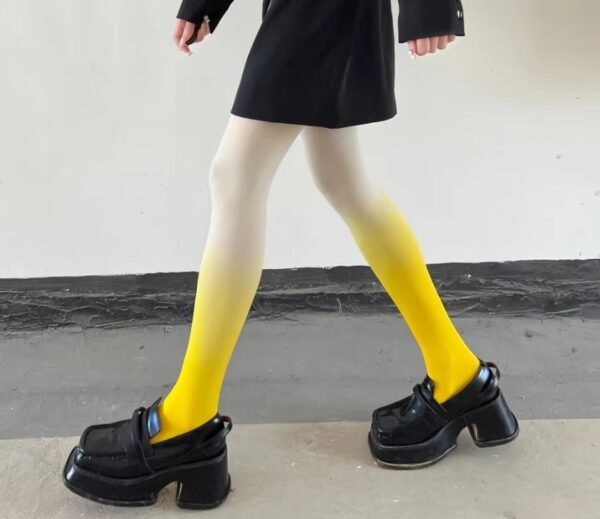 woman walking in yellow colorful gradient tights, black loafers and a black dress