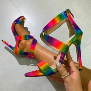 woman wearing one colorful rainbow heel and holding the other one