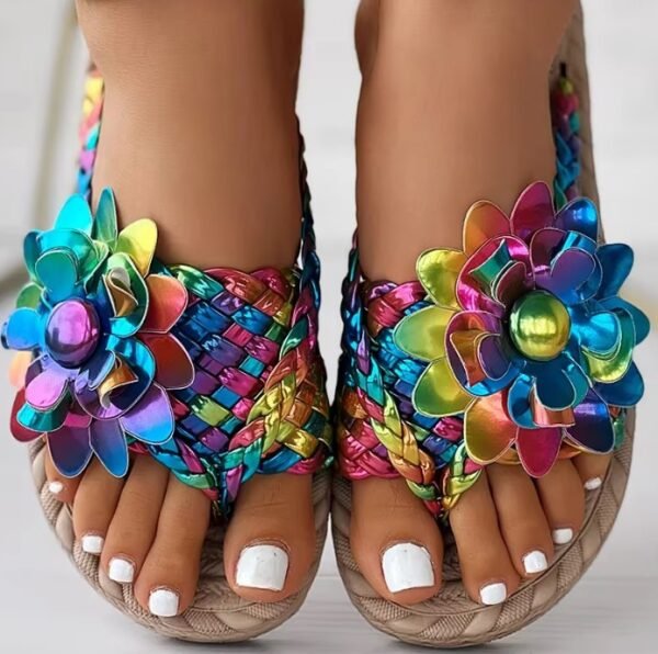 woman wearing colorful summer sandals, she has white nail polish on her toes.