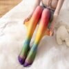 woman wearing rainbow tights, white bedsheets under her