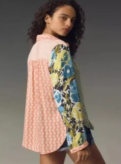 woman turned to her back wearing 90s colorful blouse, grey background