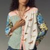 woman with brown curly hair wearing 90s colorful blouse