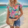 woman wearing Hawaiian colorful blouse, the beach in the background